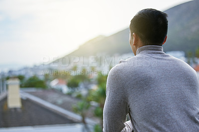 Buy stock photo Shot of a young man admiring the view at home