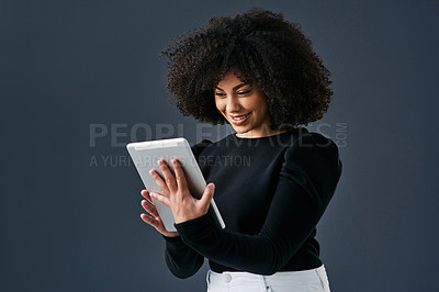 Buy stock photo Shot of a young businesswoman using a digital tablet against a studio background