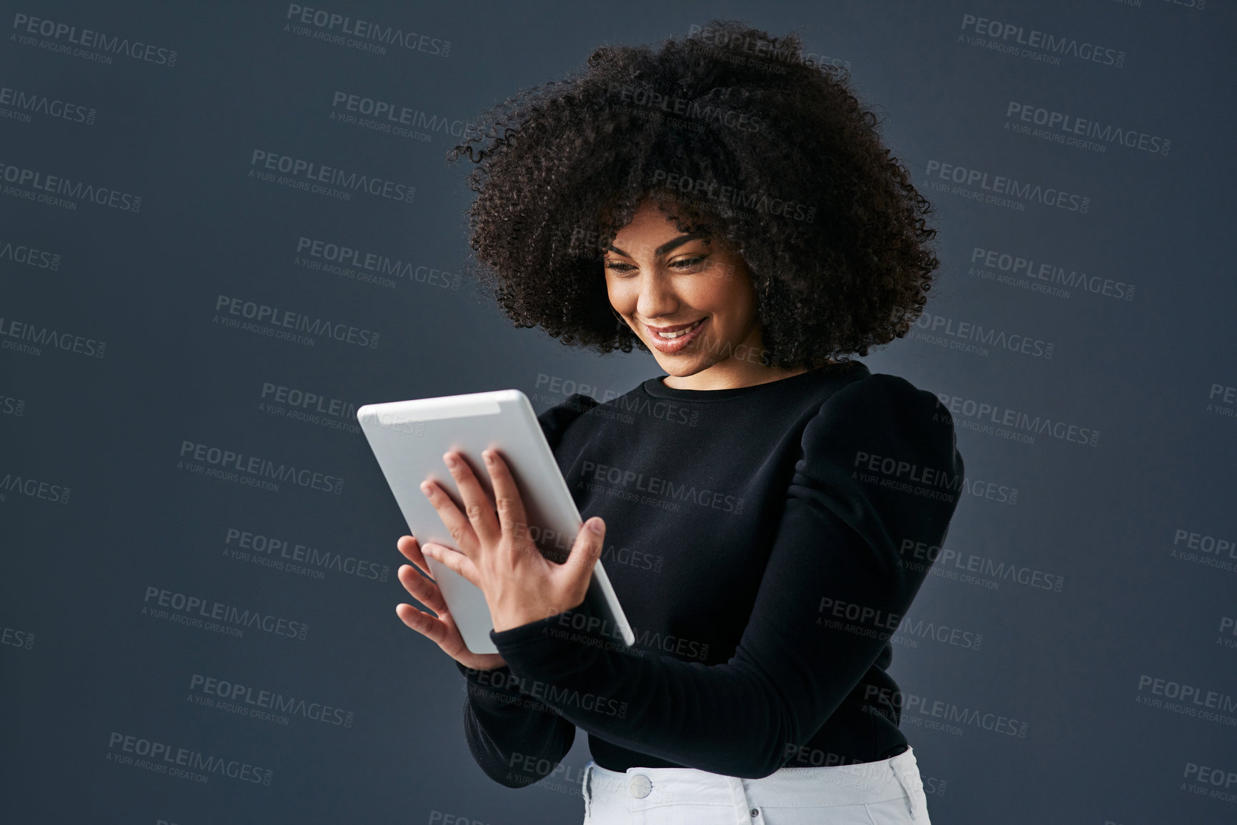 Buy stock photo Shot of a young businesswoman using a digital tablet against a studio background