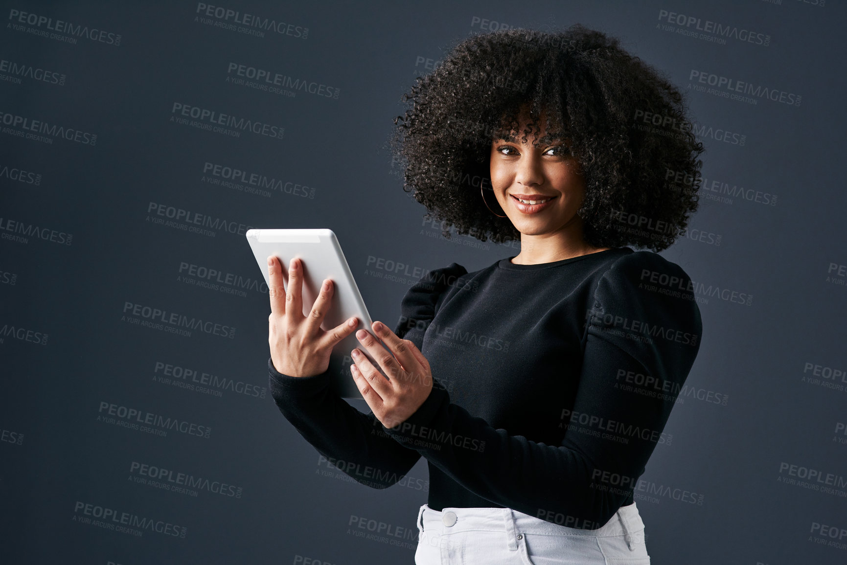 Buy stock photo Shot of a young businesswoman using a digital tablet against a studio background