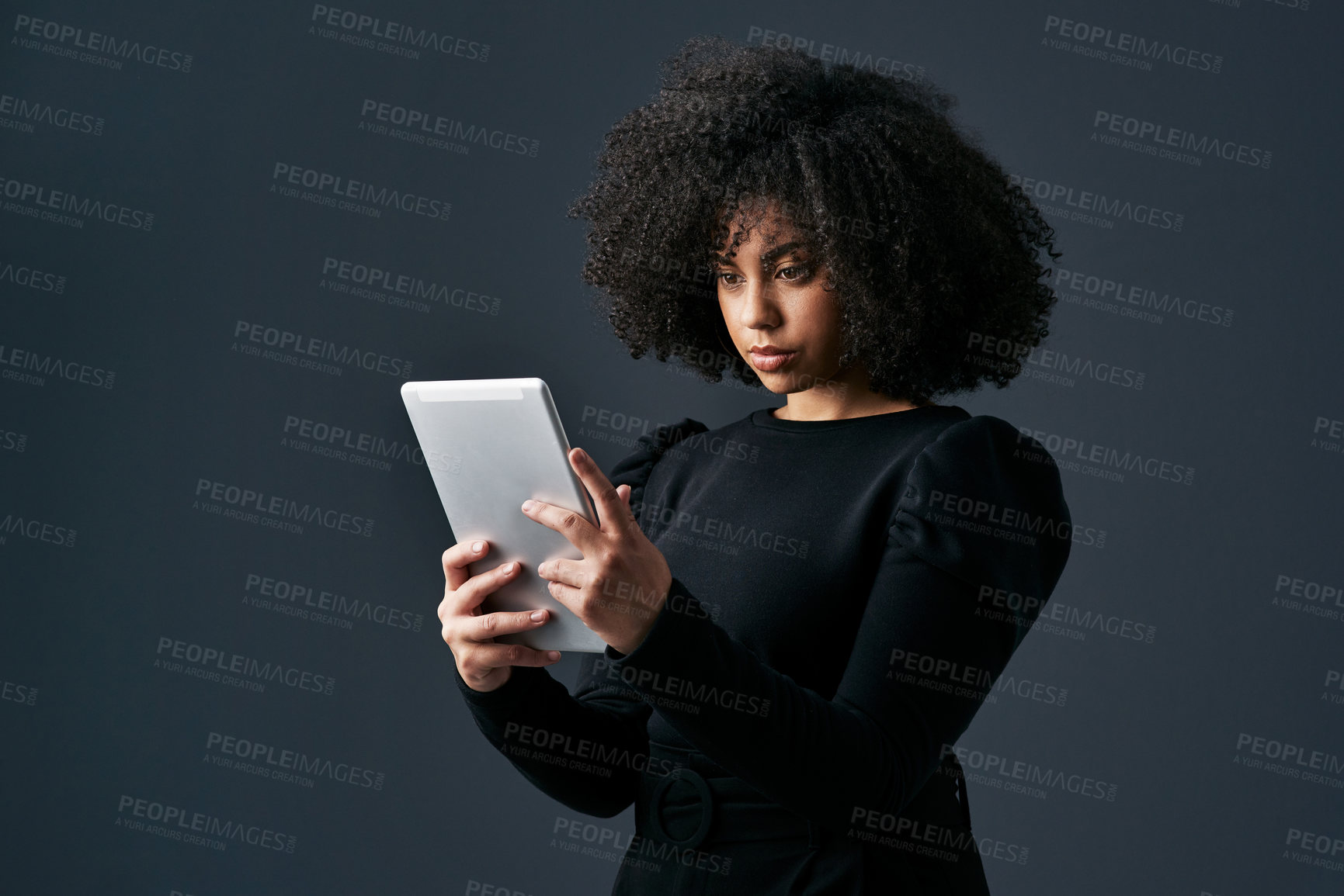 Buy stock photo Shot of a young businesswoman using a digital tablet against a studio background