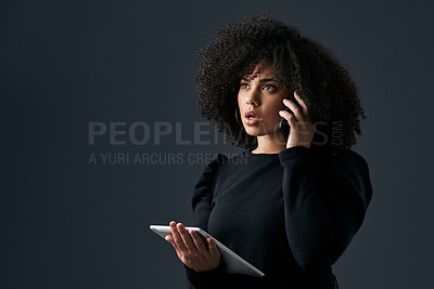Buy stock photo Shot of a young businesswoman using her smartphone and digital tablet against a studio background