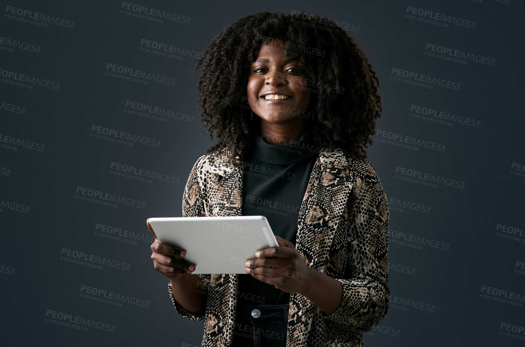 Buy stock photo Shot of a young businesswoman using a digital tablet against a studio background