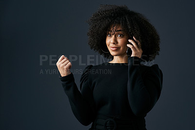 Buy stock photo Shot of a young businesswoman using her smartphone against a studio background