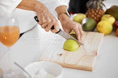 Buy stock photo Shot of a woman preparing fruit for a smoothie