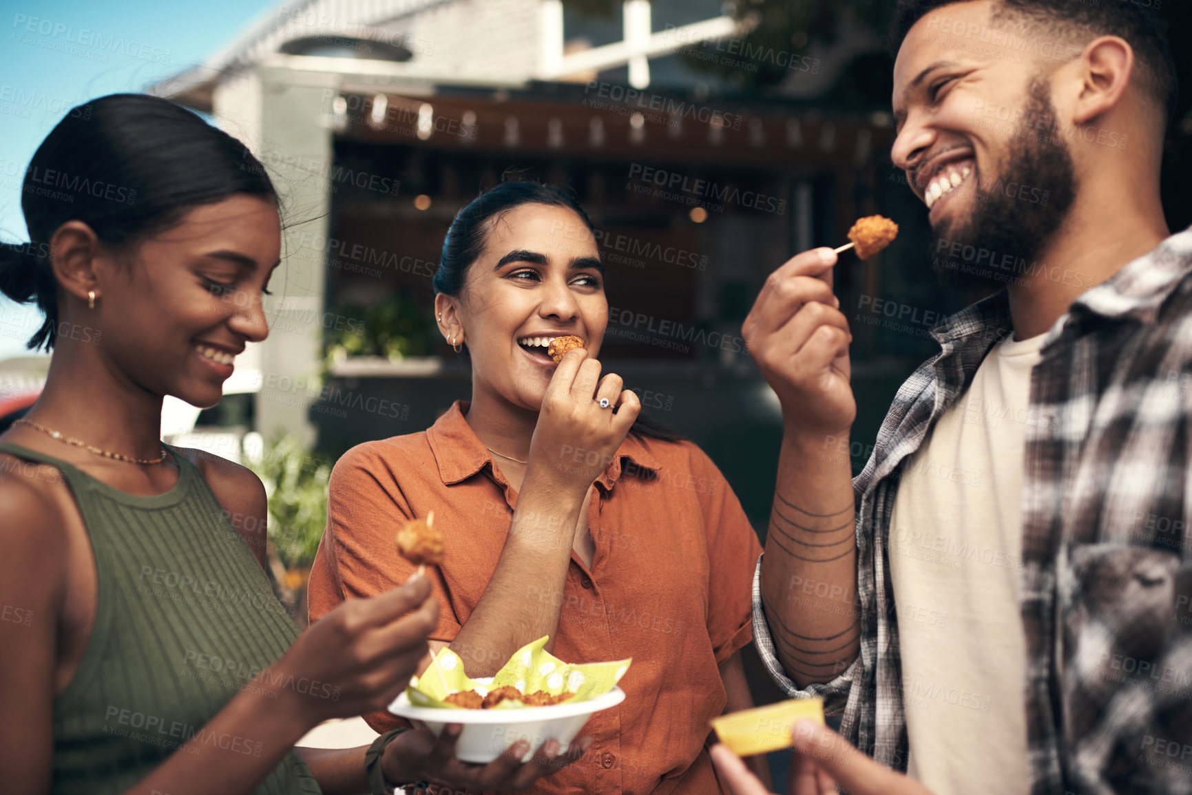 Buy stock photo Shot of a diverse group of friends standing outside a restaurant and bonding while enjoying their takeaway