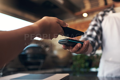 Buy stock photo Cropped shot of an unrecognizable woman standing and using her cellphone to pay for her meal at a restaurant