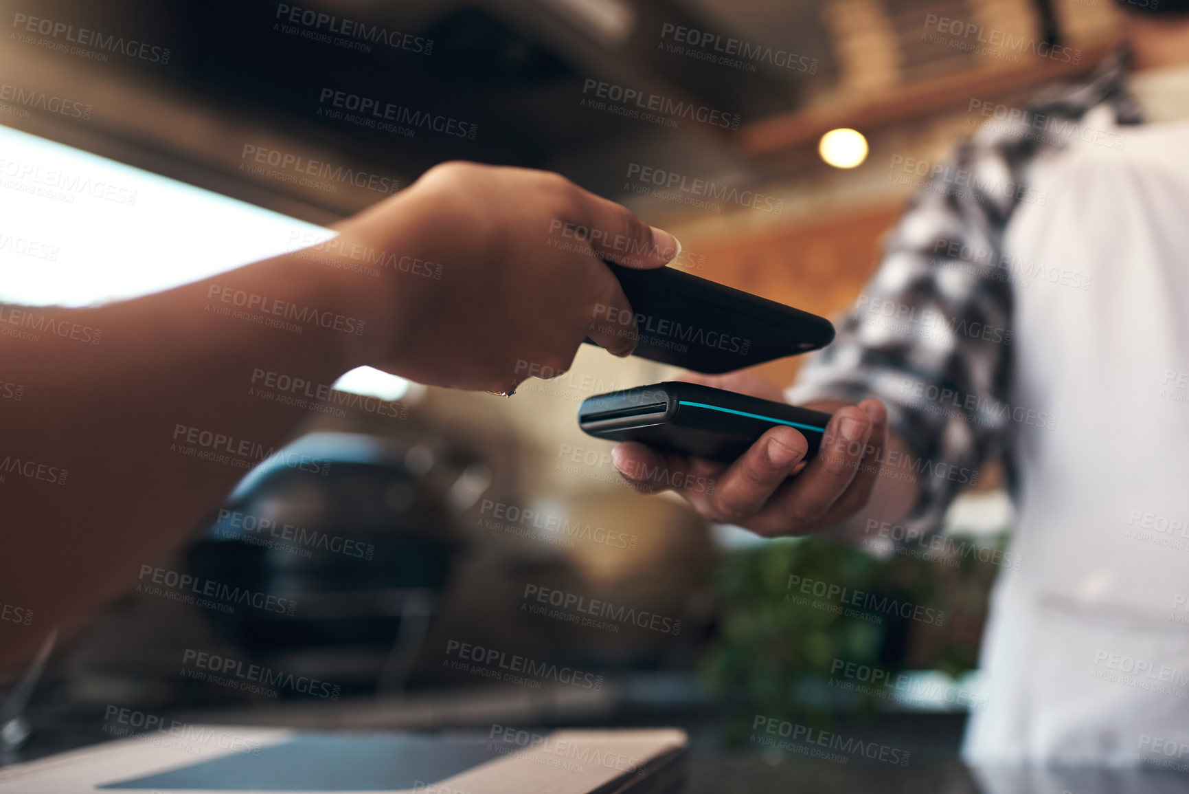 Buy stock photo Cropped shot of an unrecognizable woman standing and using her cellphone to pay for her meal at a restaurant