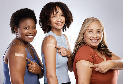 Buy stock photo Studio shot of a group of people wearing plasters after getting the Covid-19 vaccine against a grey background