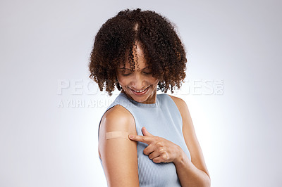 Buy stock photo Studio shot of a young woman after receiving the Covid-19 vaccine against a grey background