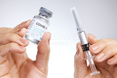 Buy stock photo Shot of a unrecognizable person holding the vaccine against a grey background
