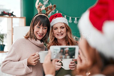 Buy stock photo Shot of three attractive woman taking Christmas pictures together at home
