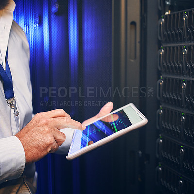 Buy stock photo Shot of an unrecognisable man using a digital tablet while working in a server room