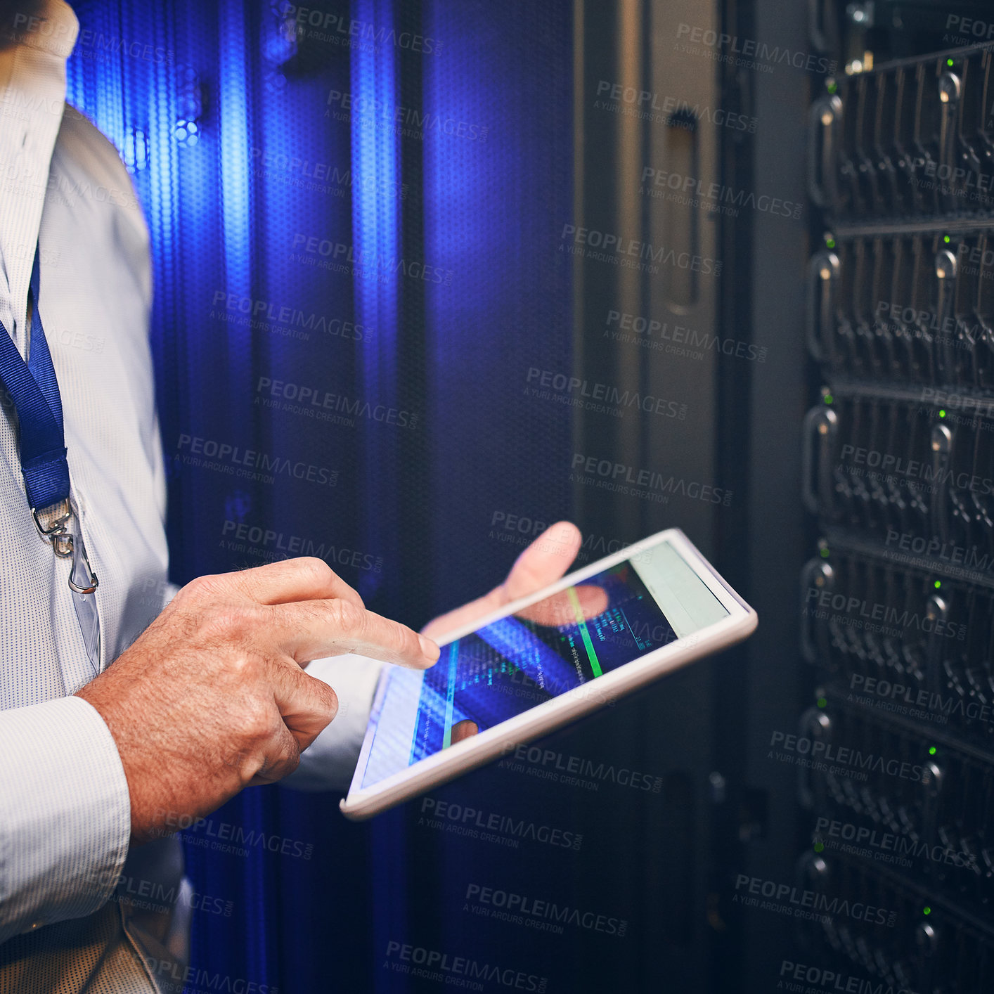 Buy stock photo Shot of an unrecognisable man using a digital tablet while working in a server room