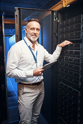 Buy stock photo Shot of a mature man using a digital tablet while working in a server room