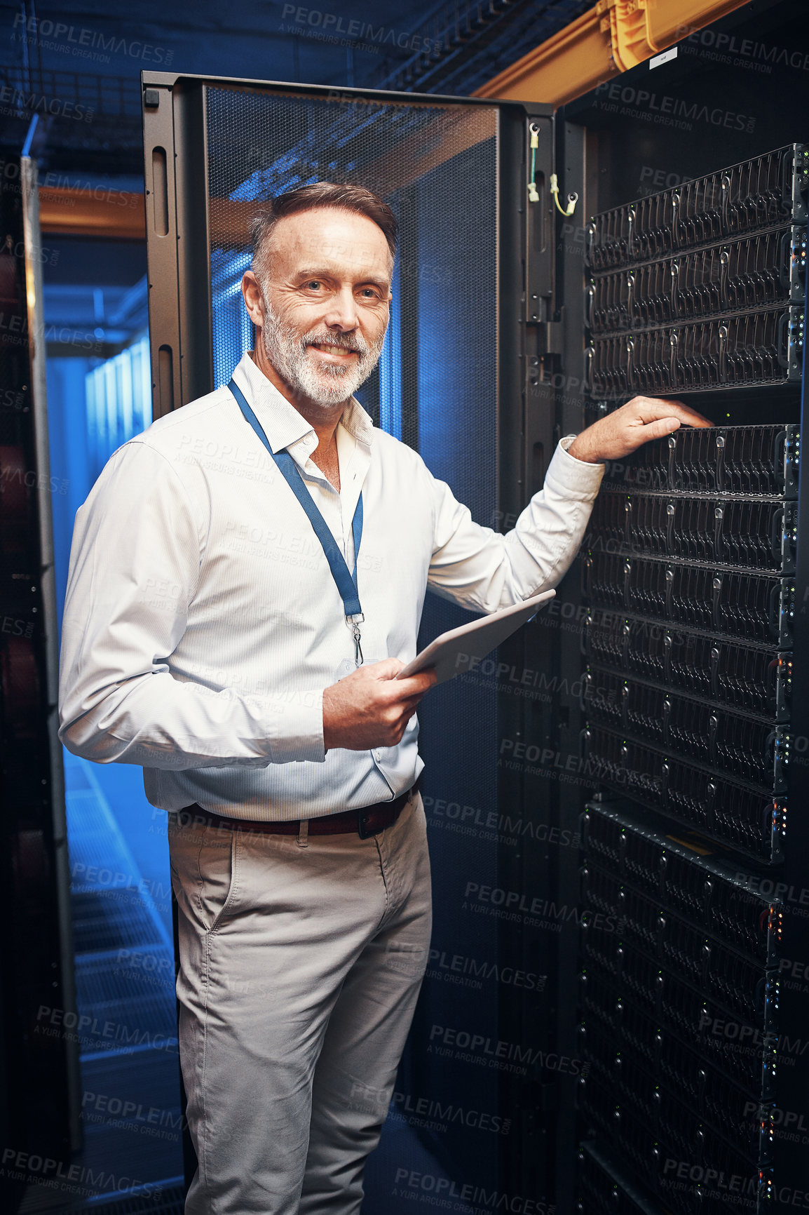 Buy stock photo Shot of a mature man using a digital tablet while working in a server room