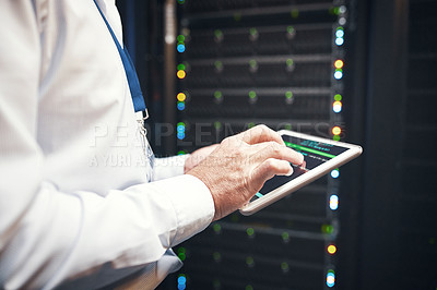 Buy stock photo Shot of an unrecognisable man using a digital tablet while working in a server room