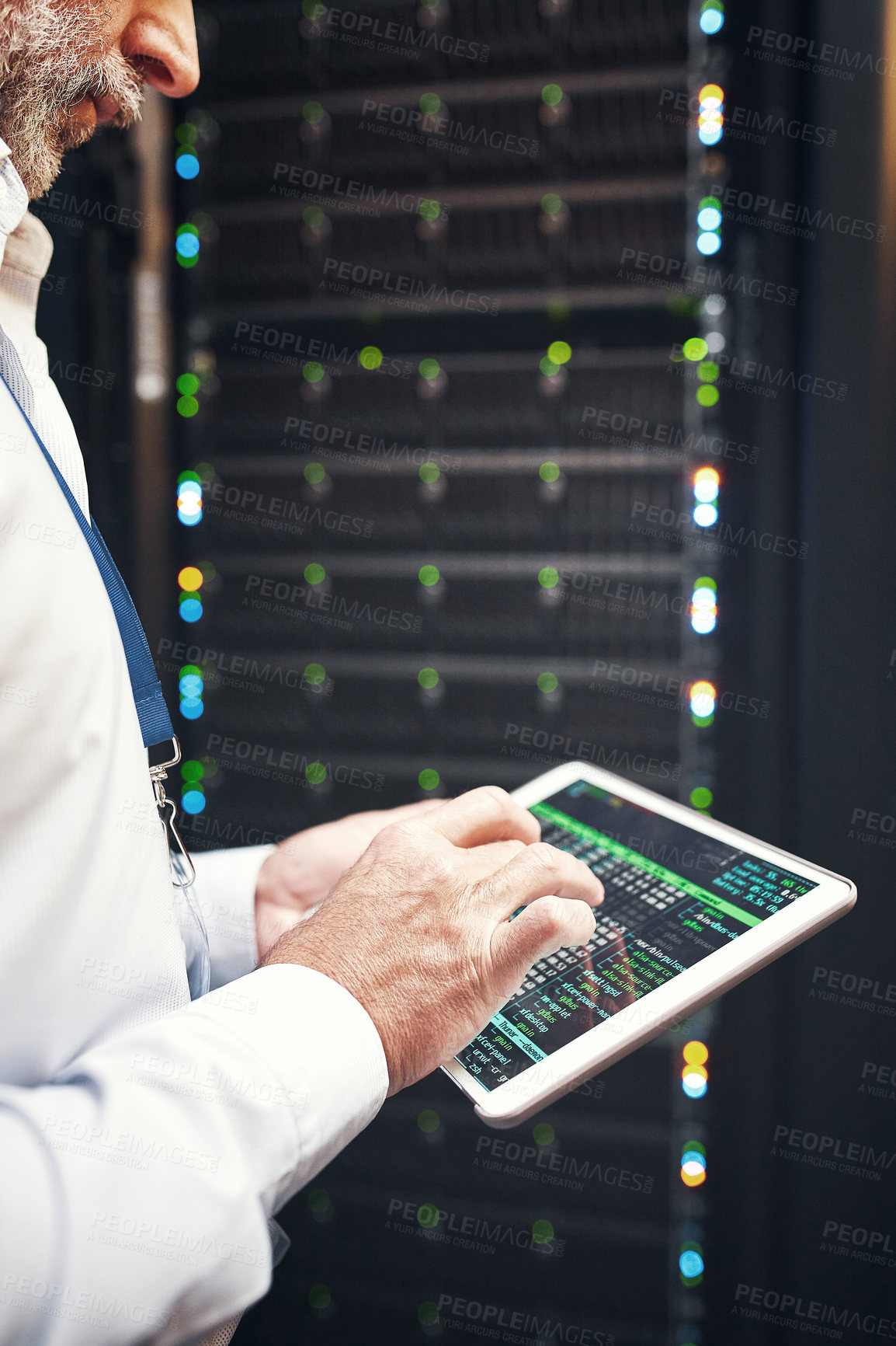 Buy stock photo Shot of a mature man using a digital tablet while working in a server room