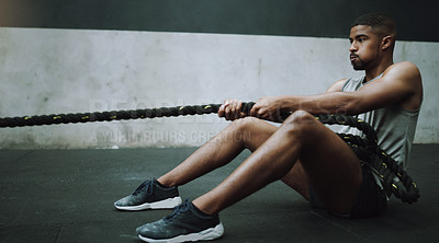 Buy stock photo Shot of a young man pulling a weight sled in a gym