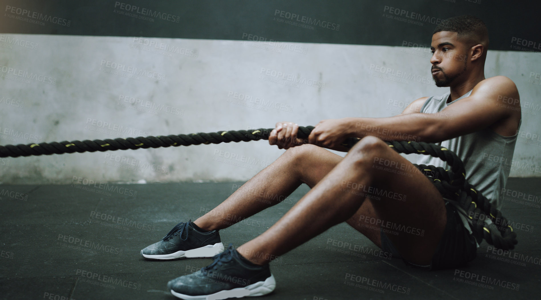 Buy stock photo Shot of a young man pulling a weight sled in a gym