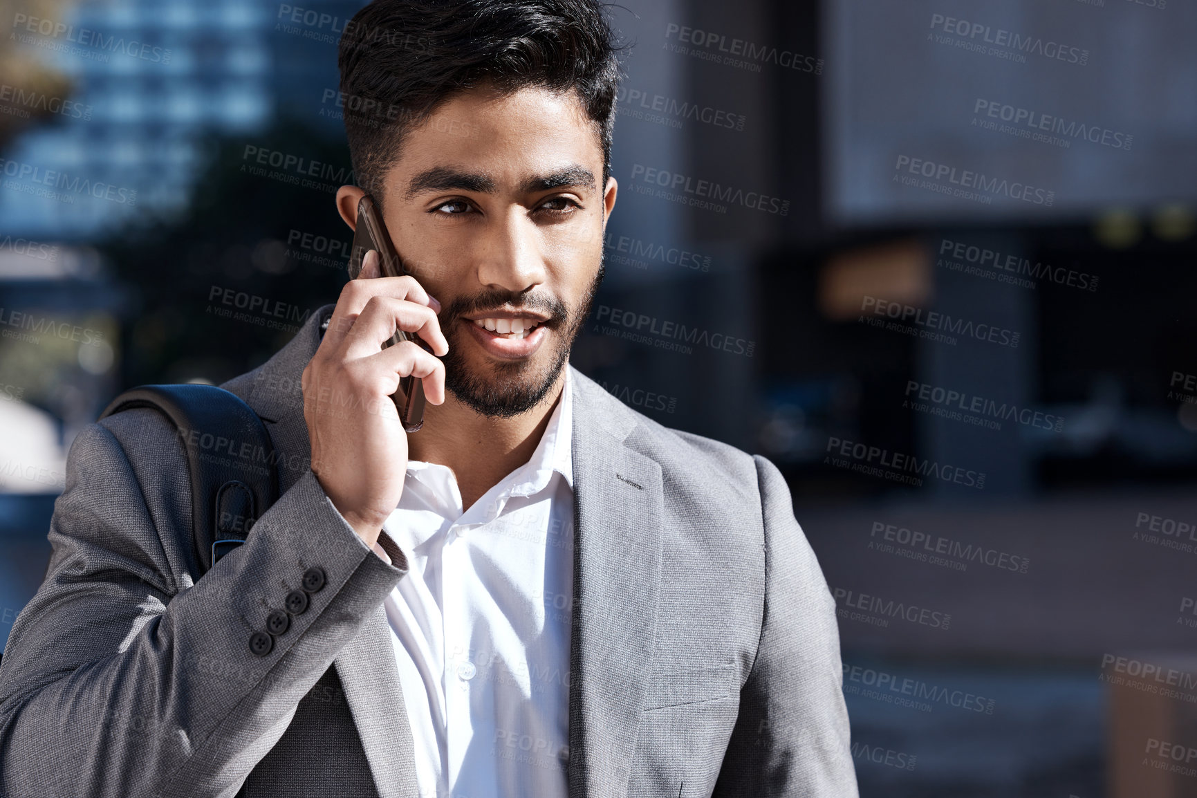 Buy stock photo Shot of a young businessman on a call in the city