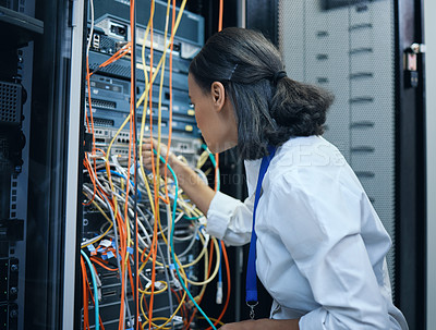 Buy stock photo Cropped shot of an attractive young female programmer working in a server room