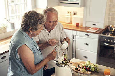Buy stock photo Shot of a senior couple making a smoothie in the kitchen at home