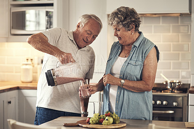 Buy stock photo Shot of a senior couple making a smoothie in the kitchen at home