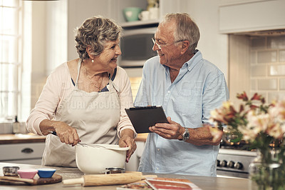 Buy stock photo Shot of a senior couple using a digital tablet while baking at home
