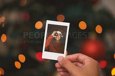 Buy stock photo Hand, christmas and picture with a person looking at a photograph of a memory on a blurred background. Home, nostalgia and holidays with an adult holding a photo to remember past memories on xmas eve