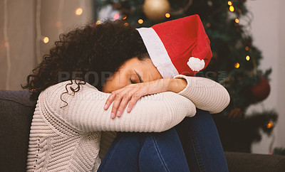 Buy stock photo Shot of a young woman looking sad during Christmas at home