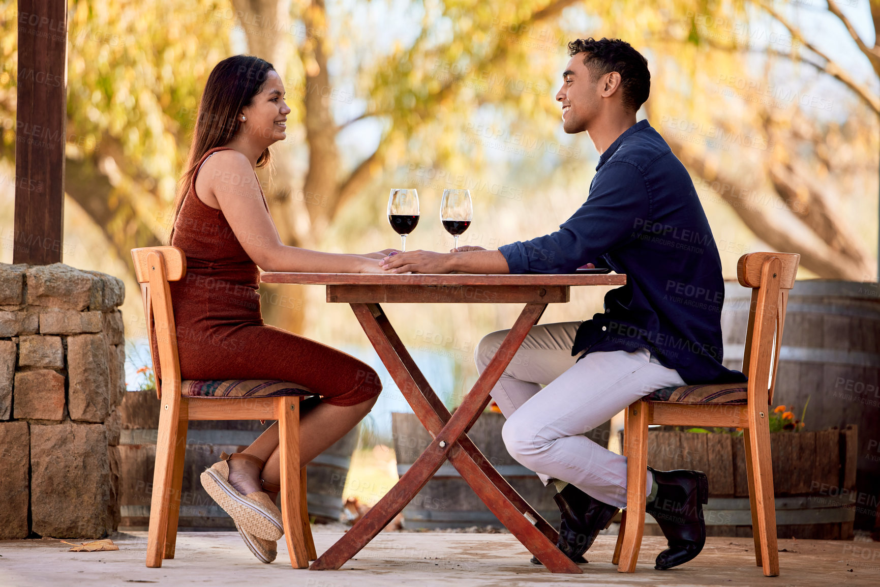 Buy stock photo Shot of a young couple having wine on a date on a wine farm