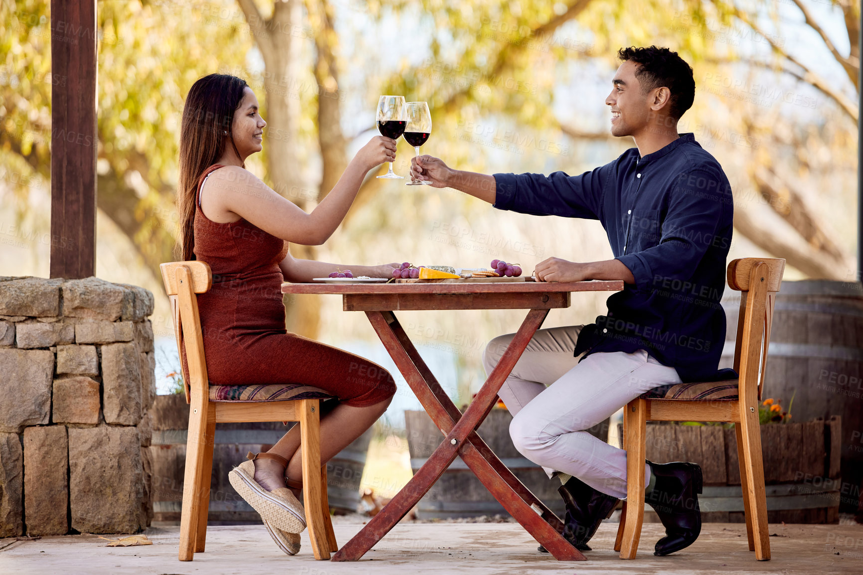 Buy stock photo Outdoor, date and couple cheers with wine, drinks and celebrate marriage at vineyard or restaurant. Happy, people and relax at luxury cafe in summer on vacation, holiday or toast on anniversary