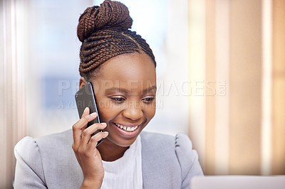 Buy stock photo Cropped shot of an attractive young businesswoman making a phonecall while working on her laptop in the office