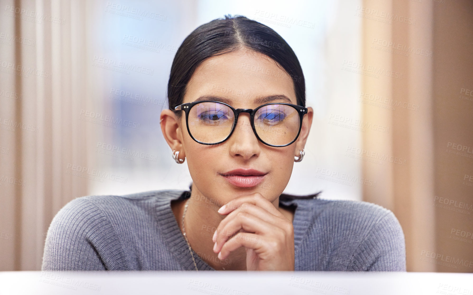 Buy stock photo Cropped shot of an attractive young businesswoman looking thoughtful while working on her laptop in the office