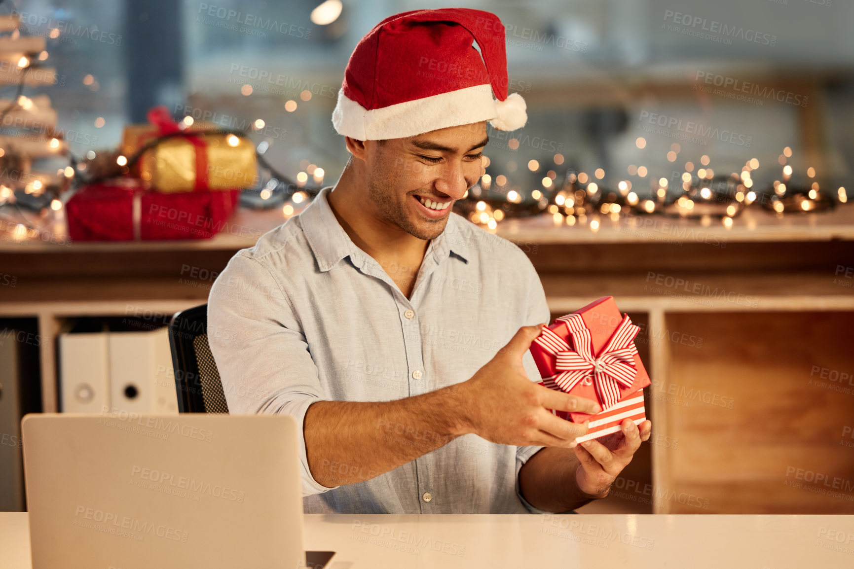 Buy stock photo Shot of a young businessman celebrating Christmas at work