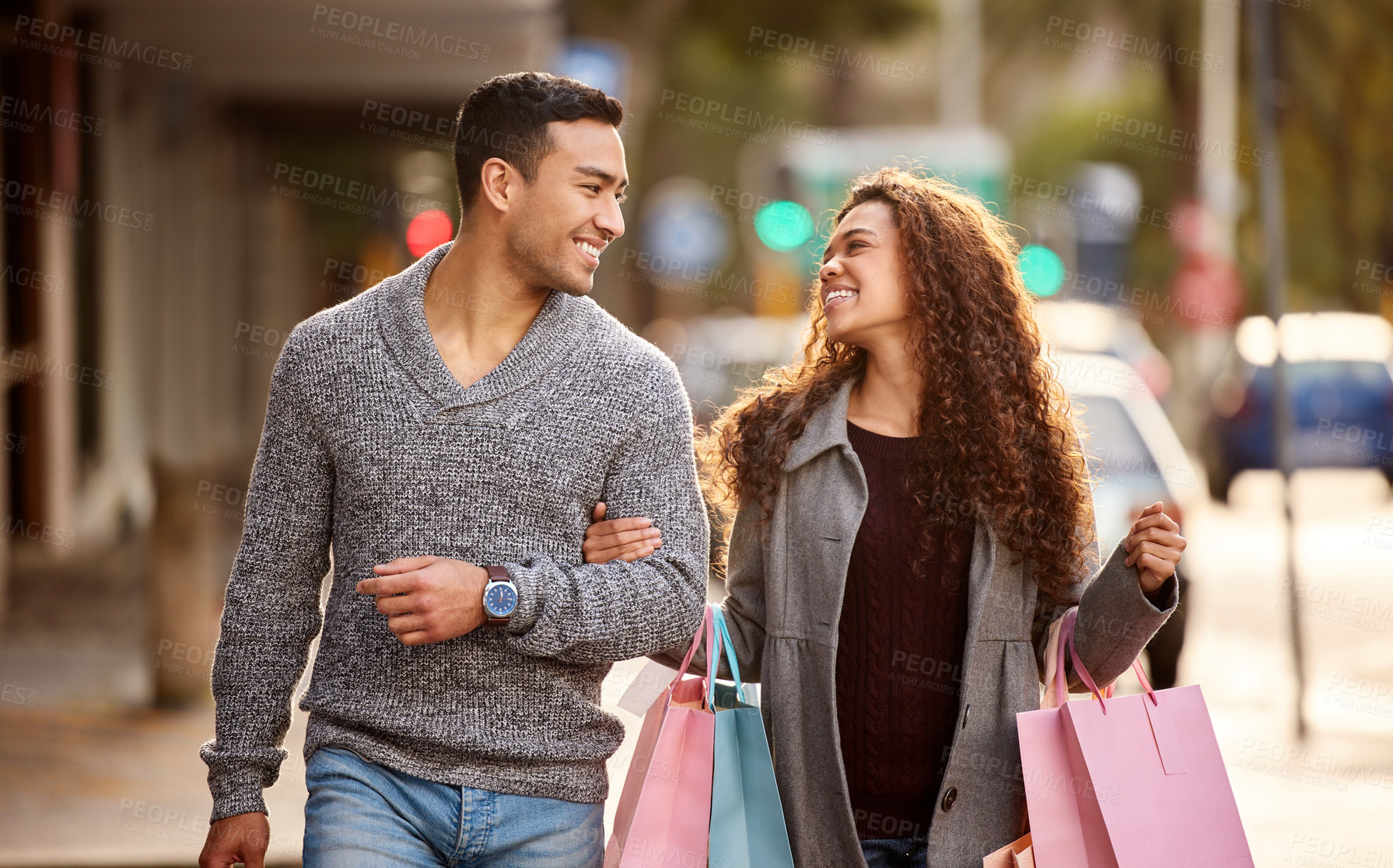 Buy stock photo Cropped shot of an affectionate young couple enjoying a shopping spree in the city