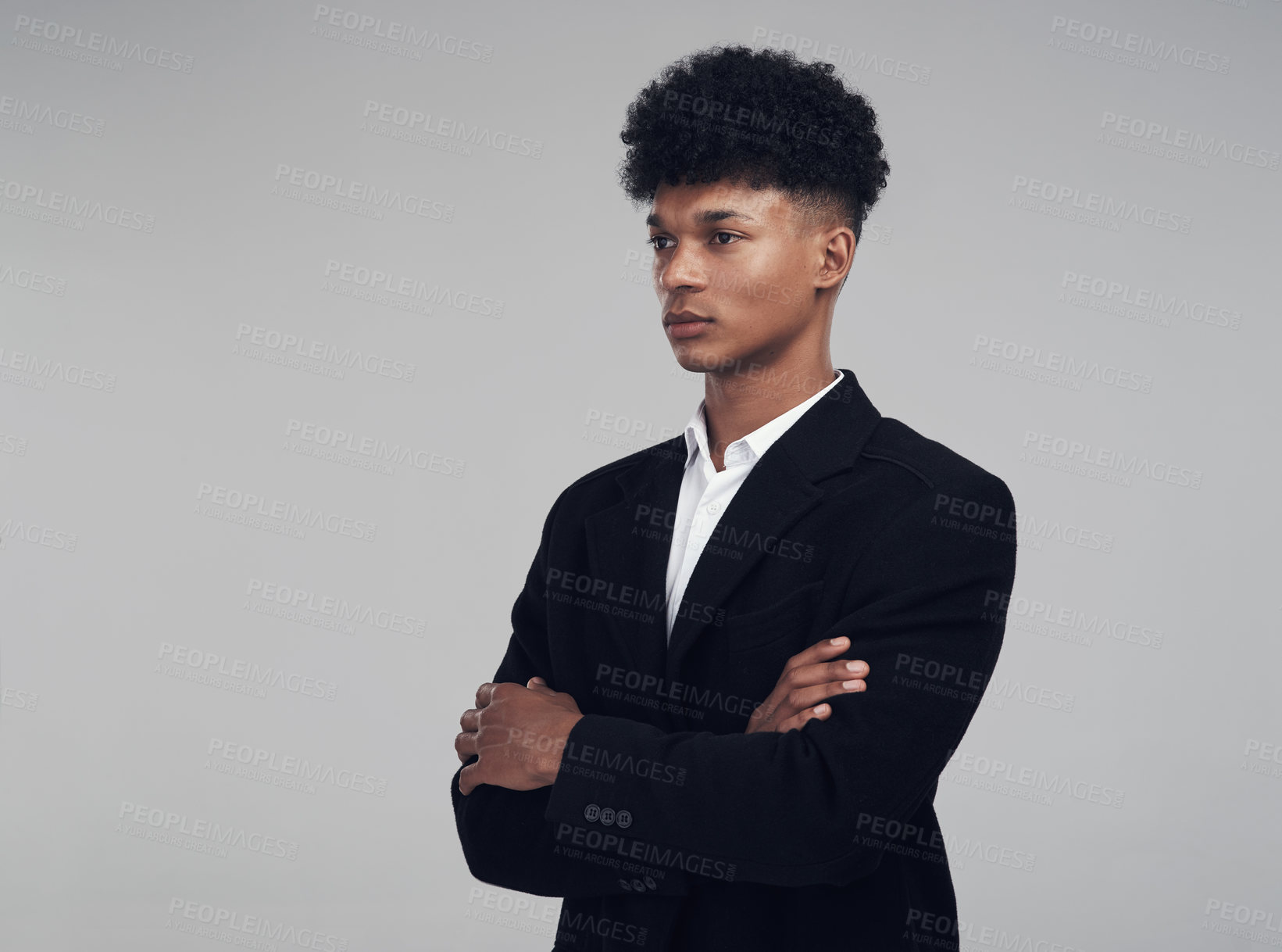 Buy stock photo Studio shot of a young businessman looking away thoughtfully against a grey background