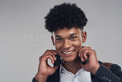 Buy stock photo Portrait of a young businessman using headphones against a grey background
