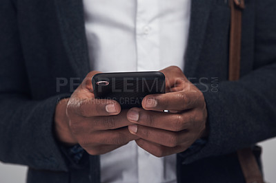 Buy stock photo Studio shot of an unrecognisable businessman using a smartphone against a grey background
