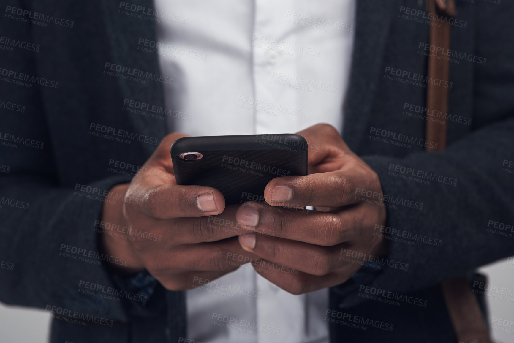 Buy stock photo Studio shot of an unrecognisable businessman using a smartphone against a grey background