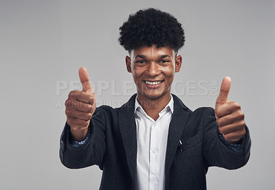Buy stock photo Studio shot of a young businessman showing thumbs up against a grey background