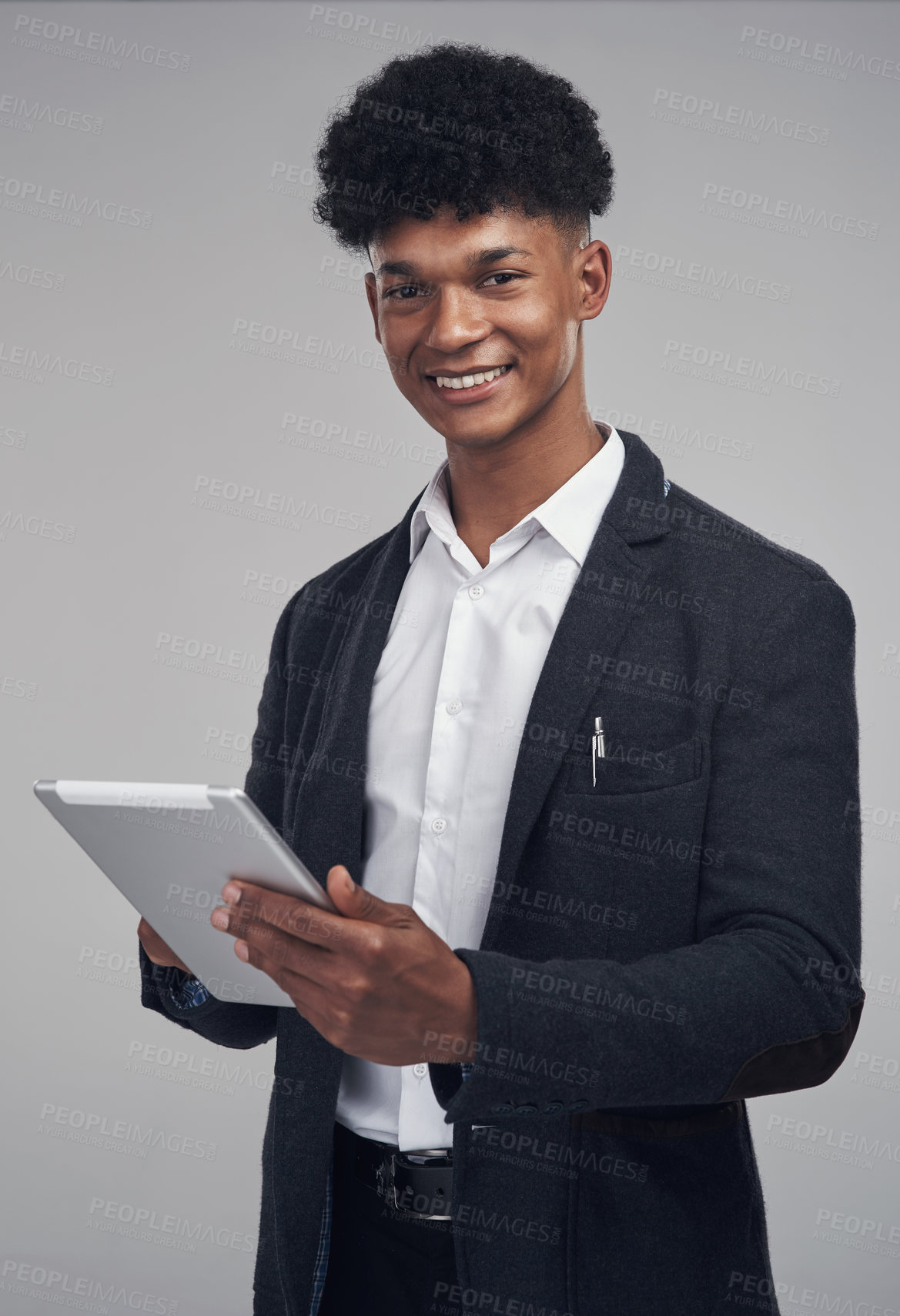 Buy stock photo Studio shot of a young businessman using a digital tablet against a grey background