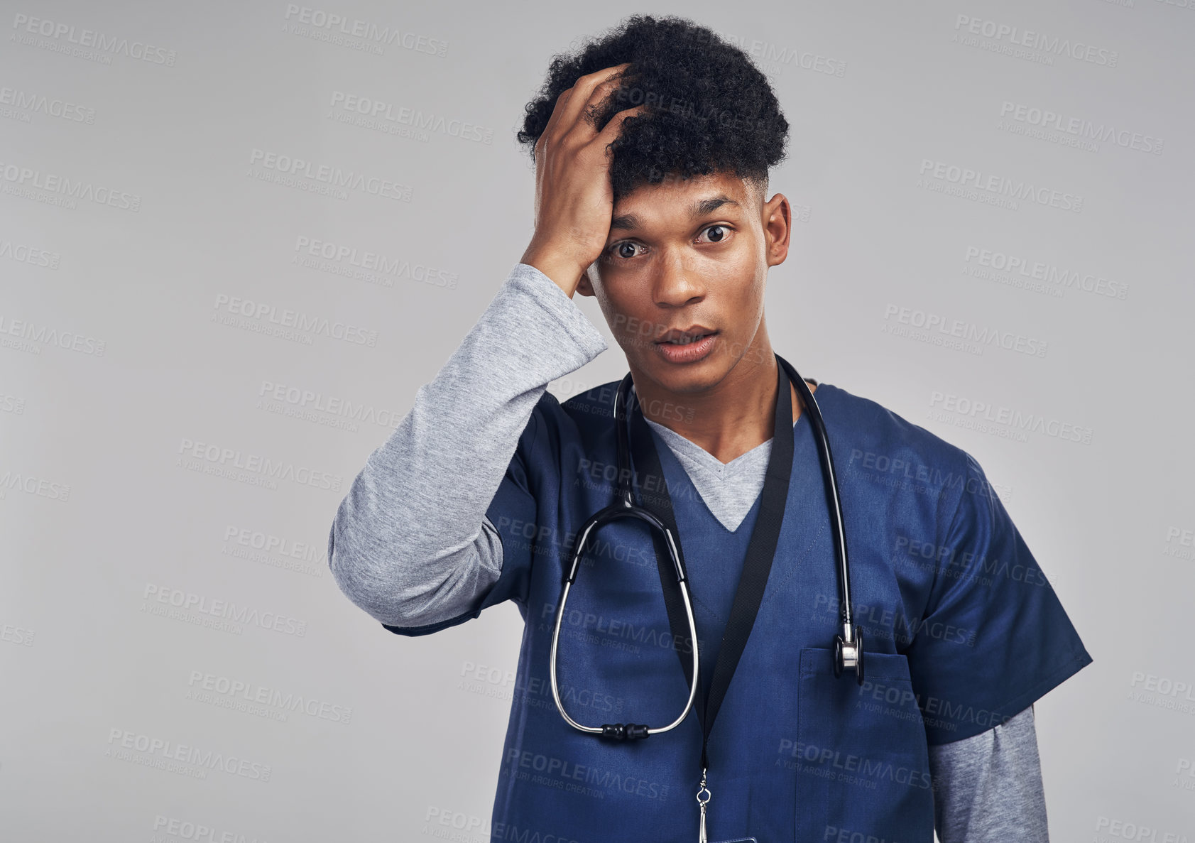Buy stock photo Shot of a male nurse looking stressed while standing against a grey background