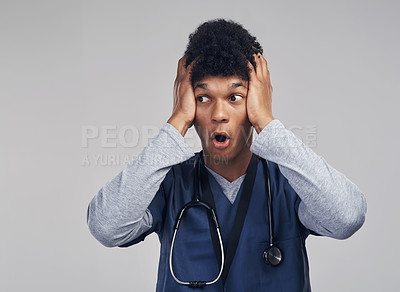 Buy stock photo Shot of a male nurse looking astonished while standing against a grey background