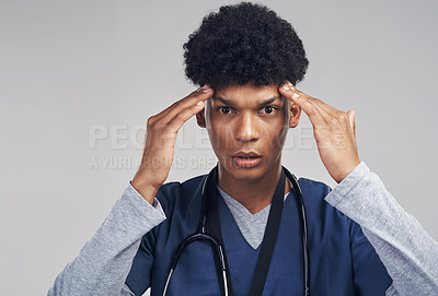 Buy stock photo Shot of a male nurse looking frustrated while standing against a grey background