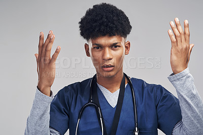 Buy stock photo Shot of a male nurse looking confused while standing against a grey background