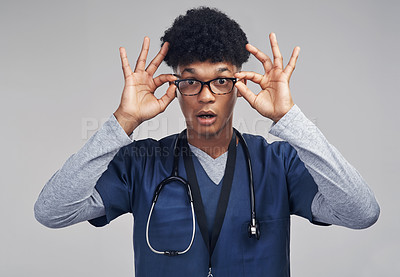 Buy stock photo Shot of a male nurse wearing glasses while standing against a grey background