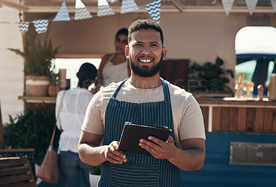 Buy stock photo Shot of a young business owner using his digital tablet