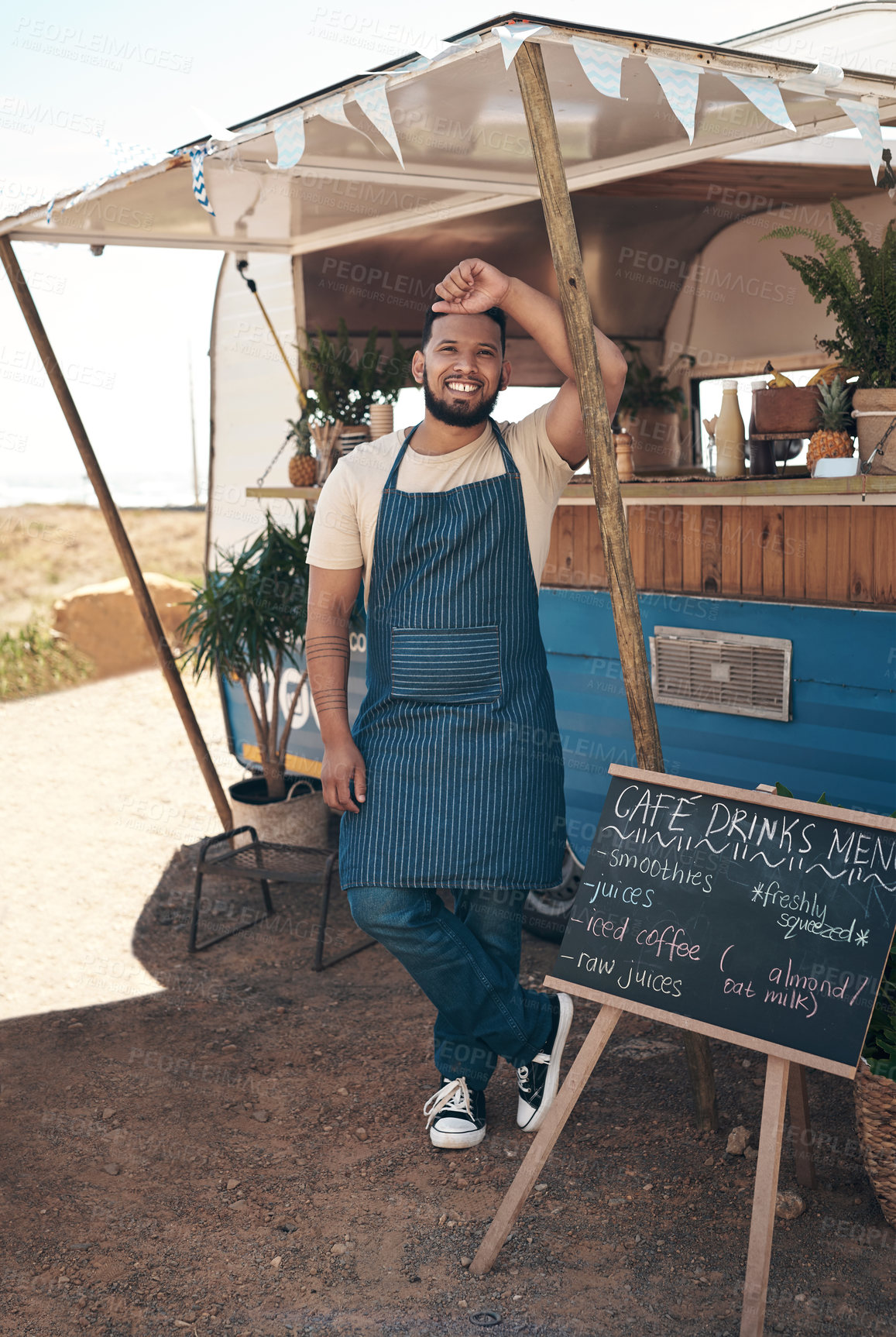 Buy stock photo Shot of a young businessman standing outside of his food truck